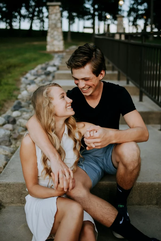 Ein verliebtes Paar sitzt lachend und eng umschlungen auf einer Treppe – ein Moment voller Liebe und Glück. Alles Liebe zum Geburtstag, mein Herz! Möge jeder Tag mit dir so voller Freude, Lachen und Nähe sein wie dieser Augenblick. Romantische Geburtstagswuensche!